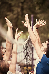 Image showing group of young friends playing Beach volleyball