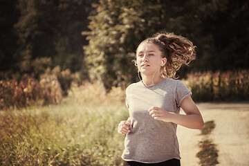 Image showing woman jogging along a country road