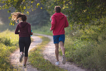 Image showing young couple jogging along a country road