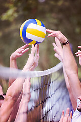 Image showing group of young friends playing Beach volleyball