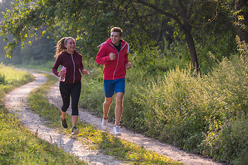 Image showing young couple jogging along a country road