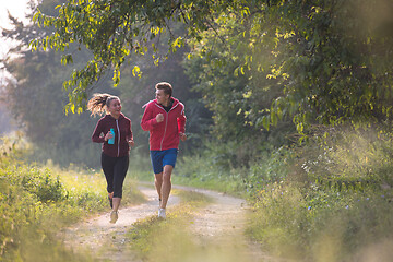 Image showing young couple jogging along a country road