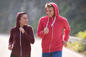 Image showing young couple jogging along a country road