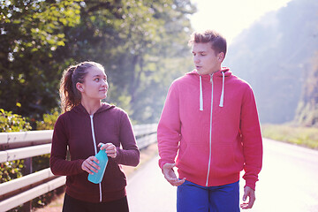 Image showing young couple jogging along a country road