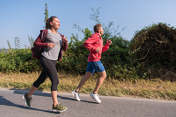 Image showing young couple jogging along a country road