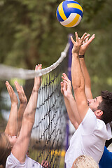 Image showing group of young friends playing Beach volleyball