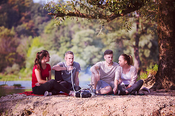 Image showing friends smoking hookah on the river bank