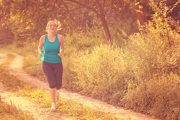 Image showing woman jogging along a country road