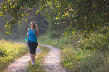 Image showing woman jogging along a country road