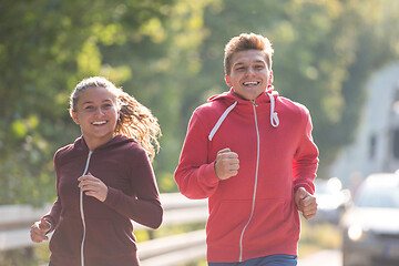 Image showing young couple jogging along a country road