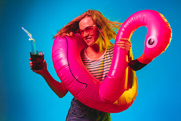 Image showing Beautiful woman in neon light isolated on blue studio background