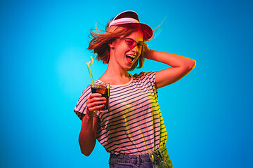 Image showing Beautiful woman in neon light isolated on blue studio background