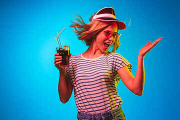 Image showing Beautiful woman in neon light isolated on blue studio background