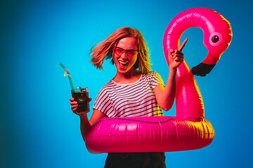 Image showing Beautiful woman in neon light isolated on blue studio background