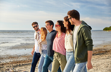 Image showing happy friends walking along summer beach