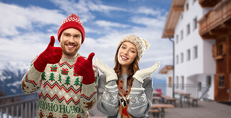 Image showing couple in ugly christmas sweaters over ski resort