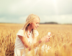 Image showing happy woman with smartphone and earphones
