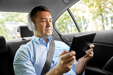 Image showing passenger with headphones using tablet pc in car