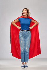 Image showing happy woman in red superhero cape