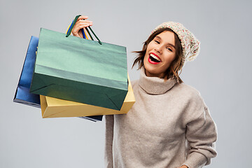 Image showing young woman in winter hat with shopping bags