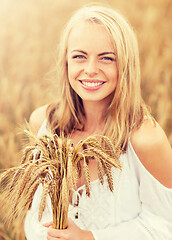 Image showing happy young woman with spikelets on cereal field