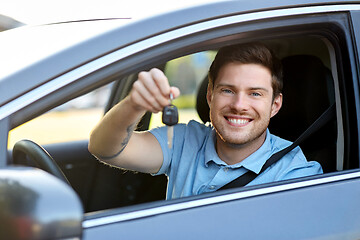 Image showing smiling man or driver with key sitting in car