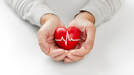 Image showing senior man holding red heart with ecg line