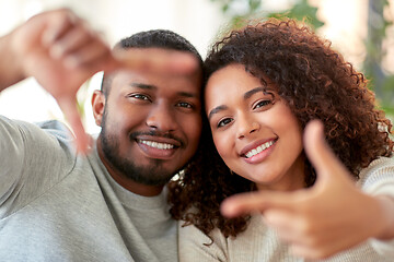 Image showing happy couple making selfie gesture at home