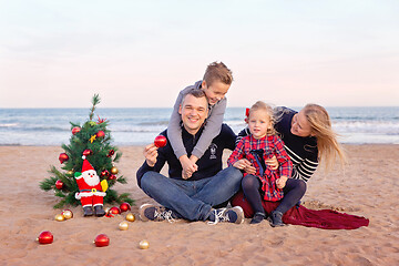 Image showing Christmas portrait of happy family on the beach