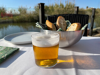 Image showing Cafe table with a glass of beer and bread