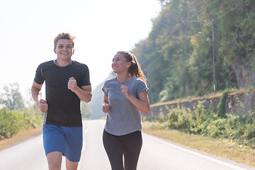 Image showing young couple jogging along a country road