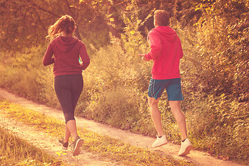 Image showing young couple jogging along a country road