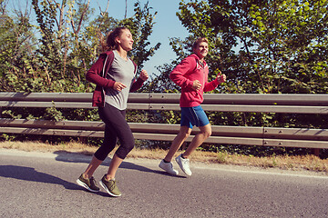 Image showing young couple jogging along a country road