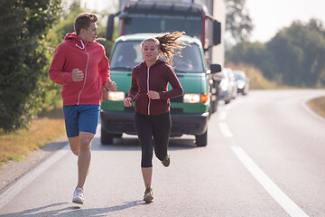 Image showing young couple jogging along a country road