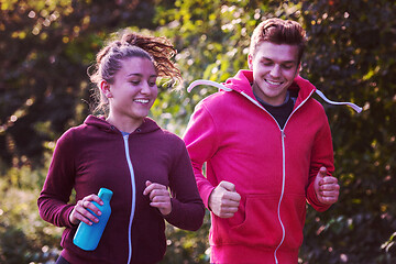 Image showing young couple jogging along a country road