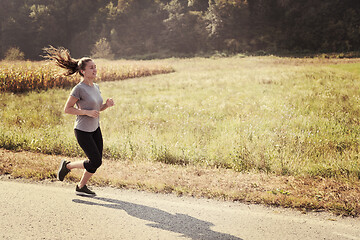 Image showing woman jogging along a country road