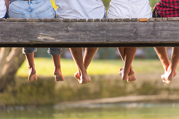 Image showing people sitting at wooden bridge