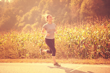 Image showing woman jogging along a country road