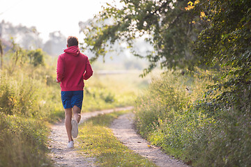 Image showing man jogging along a country road