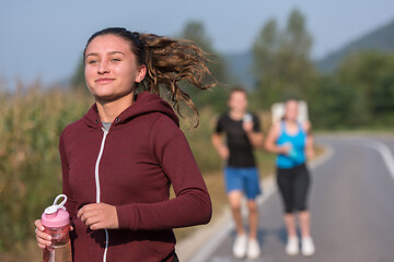 Image showing young people jogging on country road