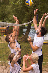 Image showing group of young friends playing Beach volleyball