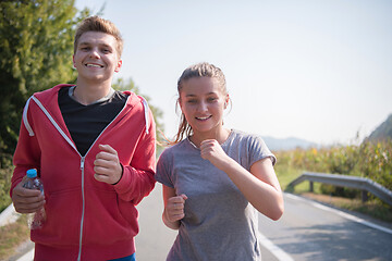 Image showing young couple jogging along a country road