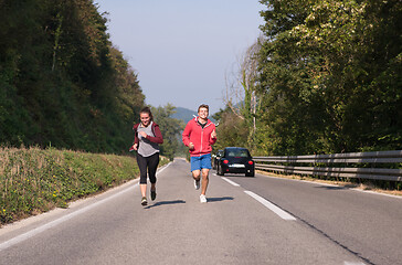 Image showing young couple jogging along a country road