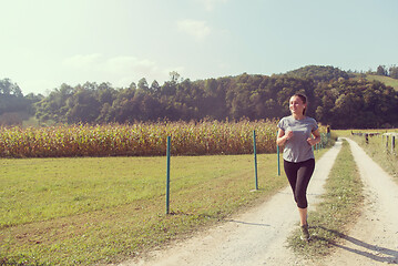 Image showing woman jogging along a country road