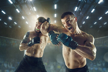 Image showing Two professional boxers boxing on the ring