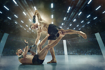 Image showing Two professional boxers boxing on the ring