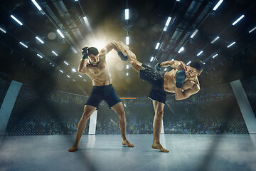 Image showing Two professional boxers boxing on the ring