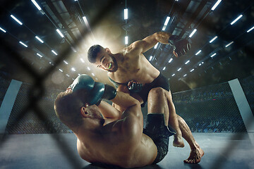 Image showing Two professional boxers boxing on the ring