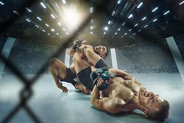 Image showing Two professional boxers boxing on the ring