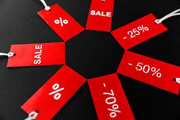 Image showing red tags with discount signs on black background